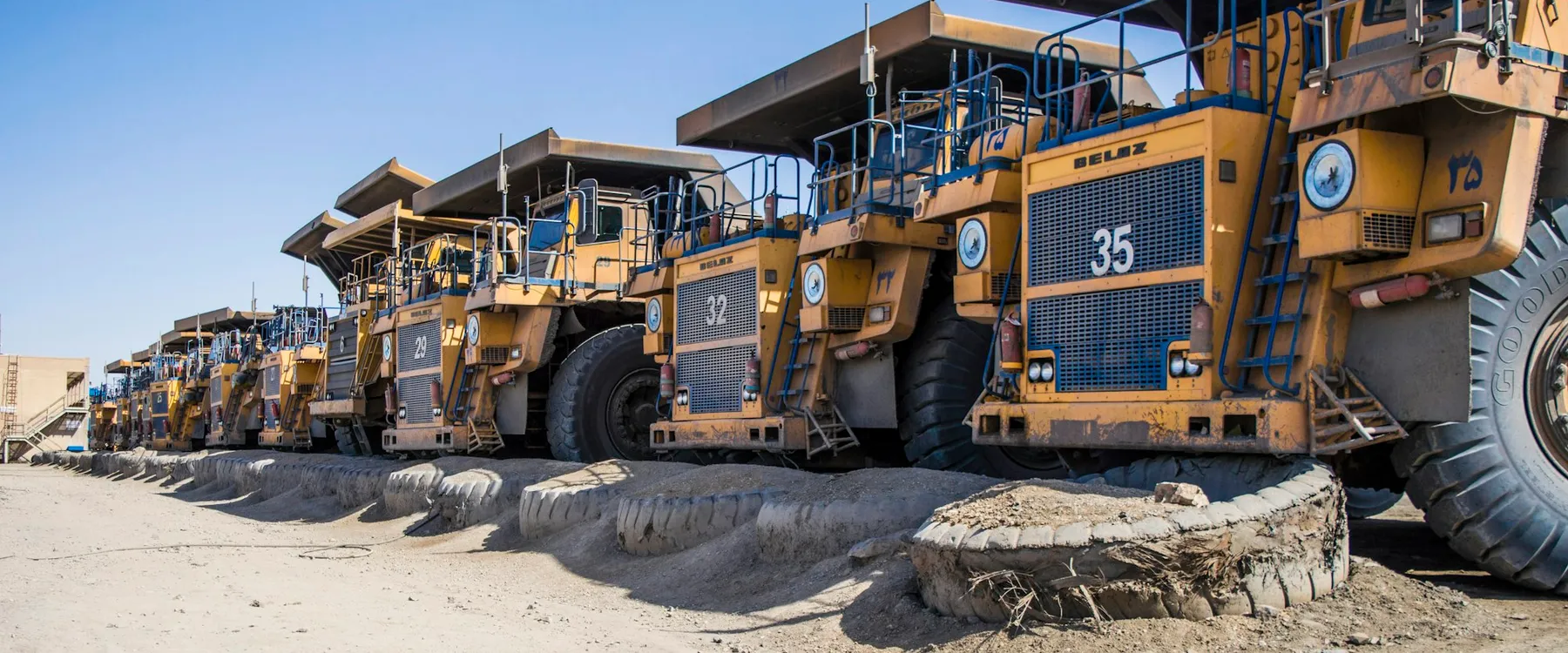 Haul trucks parked in a line at a mine