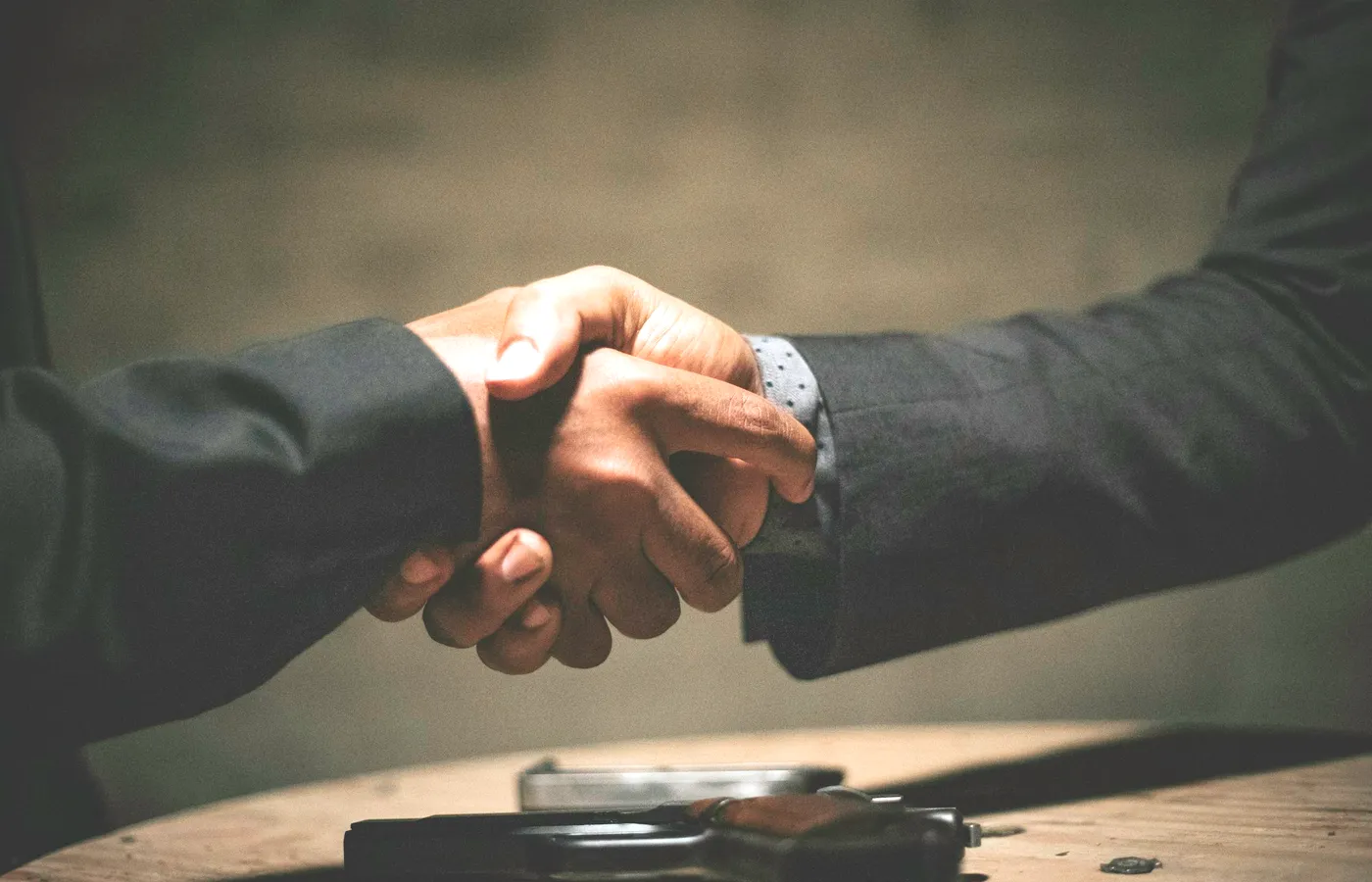 Two people shaking hands across a table