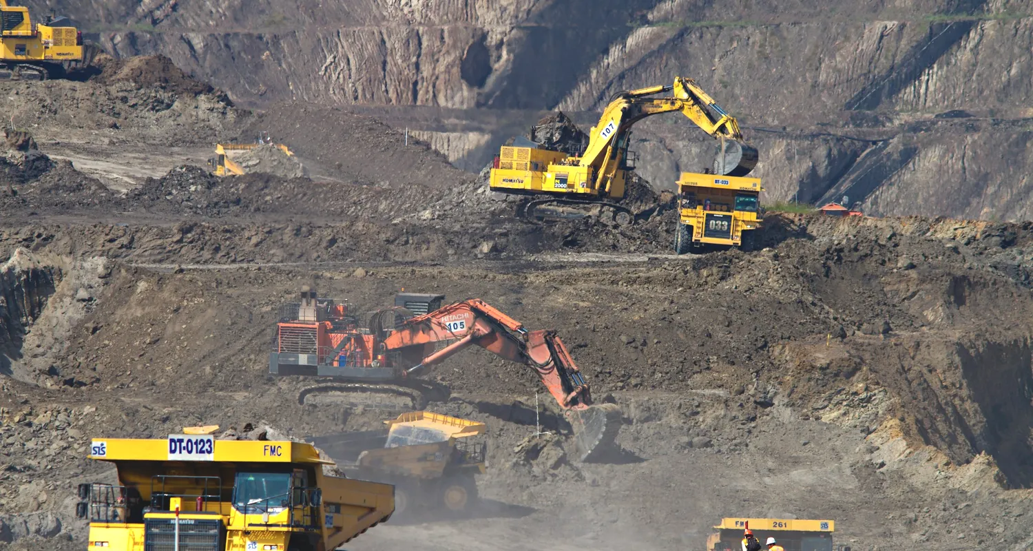 Excavators and haul trucks working a pit face
